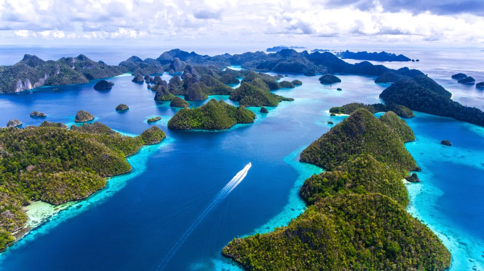 Wyspy krasowe Raja Ampat z lotu ptaka, na wodzie łódź
